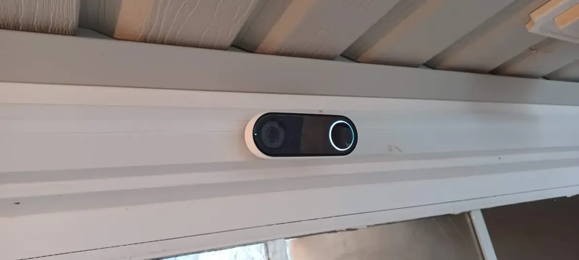 Video doorbell mounted under a covered porch with the light ring lit