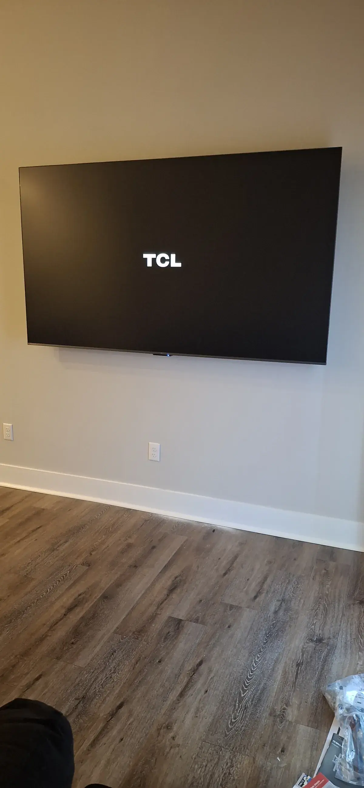Freshly wall mounted television powering up in a room with moving boxes still on the floor