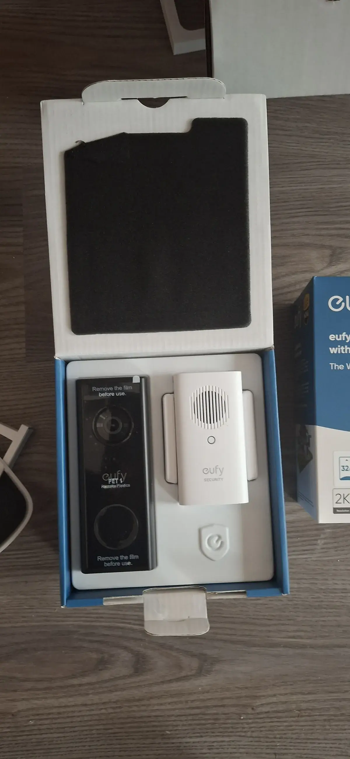 Eufy video doorbell and sensor in the product box on a table before installation